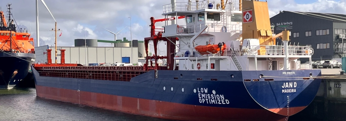 Newbuild cargo vessel “Jan D” during the handover in Groningen – vessel alongside the quay in front of wind turbines.