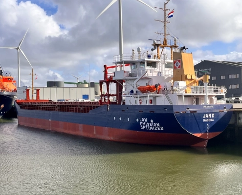 Newbuild cargo vessel “Jan D” during the handover in Groningen – vessel alongside the quay in front of wind turbines.